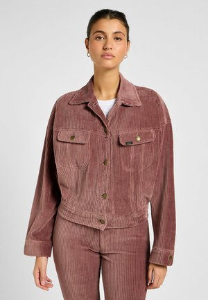 Jacket z korduroj w przykurzonym różu, z kieszeniami na piersiach, złotymi guzikami oraz skróconym krojem z szerokimi rękawami. Teksturowane pionowe paski.