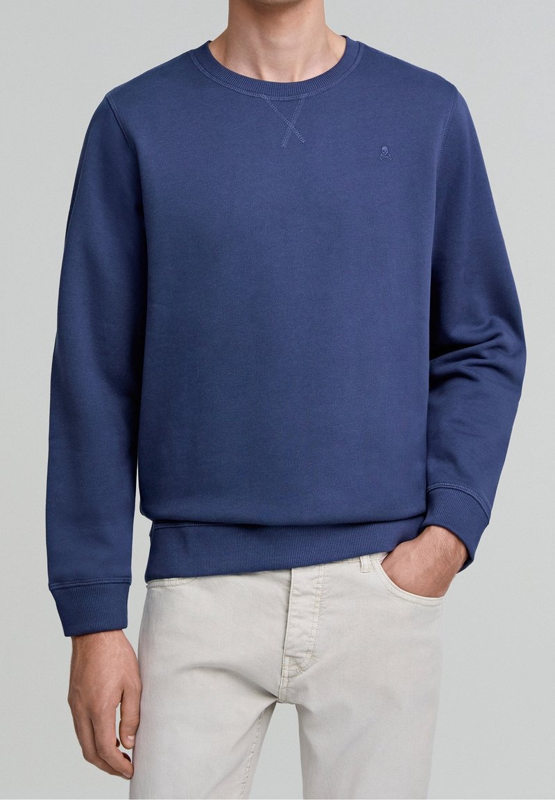Sweat-shirt bleu marine en mélange de coton ; doté d'un col rond et de poignets et ourlet côtelés ; petit logo sur la poitrine.