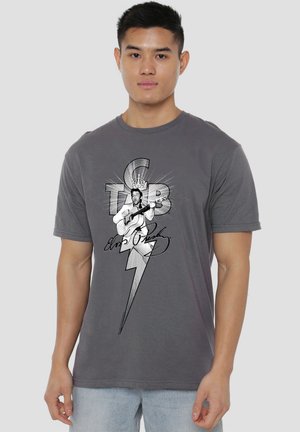 Young man wearing a gray T-shirt with a black and white Elvis Presley graphic holding a guitar, with text and a lightning bolt design.