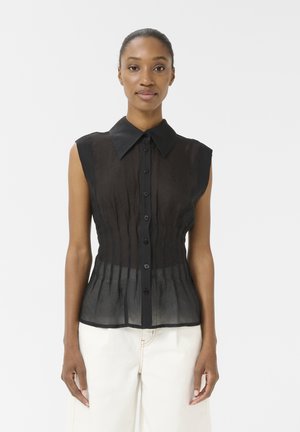 Blouse noire transparente sans manches avec un devant à bouton, un col et des détails froncés autour de la taille, en tissu texturé et avec un ourlet droit.