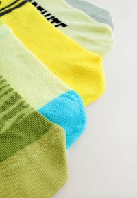 Neli paari sokke erinevates toonides: roheline, kollane, heledat kollane ja sinine; funktsioneerib tekstuursete kudumitega ning kontrastsete varvaste värvidega.