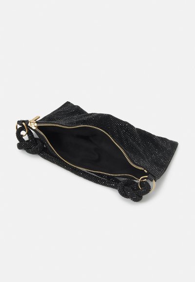 Schwarze Tasche mit strukturierter Oberfläche, verziert mit Perlen, einem Innenfutter und einem goldenen Reißverschluss. Enthält ein Knoten-Handgriff-Detail.