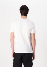 Tricou alb din bumbac cu guler rotund și mâneci scurte, având un design simplu și fără modele sau accente vizibile.