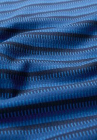 Miękka tkanina z naprzemiennymi ciemnoniebieskimi i jasnoniebieskimi poziomymi paskami oraz małymi pionowymi wzorami w postaci kresek, przedstawiona w zbliżeniu na zgięcia.