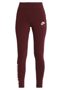 Burgunderfärgade Nike leggings med hög midja, figurnära design och en vit "Nike Air"-logotyp framtill och på sidan för varumärkesidentifikation.