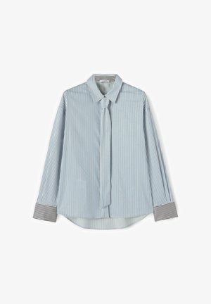 Camicia a maniche lunghe con righe verticali azzurro chiaro e bianche, con polsini a righe nere e bianche e cravatta sottile attaccata.