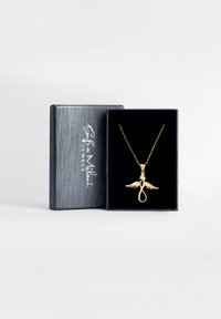 Guldfarvet vedhængs kæde med en løkke og vingedesign, præsenteret i en sort, tekstureret gaveæske med præget logo. Kæden er inkluderet.