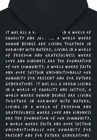 Čierna mikina s kapucňou, na ktorej je biele ručne písané textové posolstvo o rovnosti, spravodlivosti a harmónii; vyrobená z jemnej bavlny s voľným strihom.