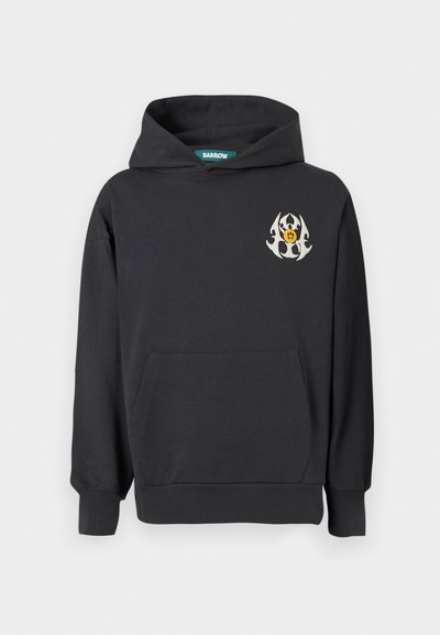 Sweatshirt preto com um emblema central que apresenta um rosto amarelo e elementos de design brancos. Possui um bolso frontal e punhos com goma.