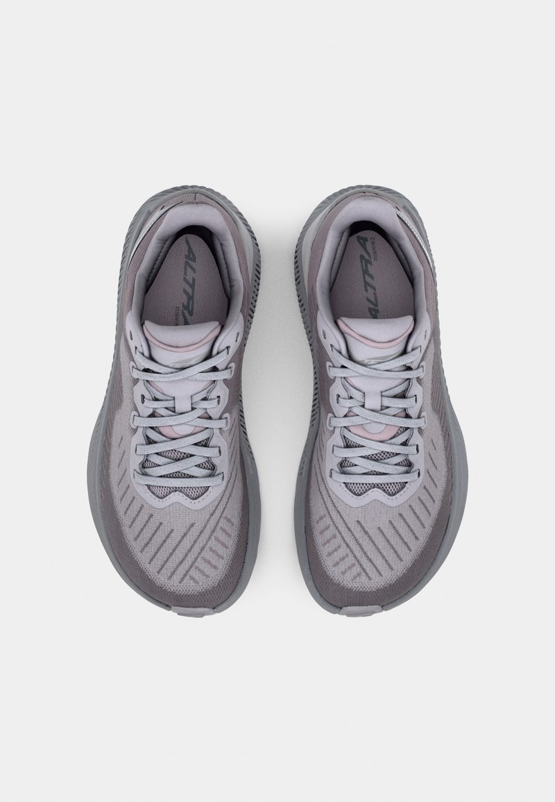 Szare buty sportowe z fakturowaną cholewką, kontrastującymi sznurowadłami i wzorzystą podeszwą. Posiadają logotyp na języku oraz oddychające siateczkowe elementy.