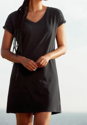 Robe noire à col en V avec des manches courtes retroussées, en tissu doux, présentant une coupe décontractée et un ourlet droit qui tombe au-dessus du genou.