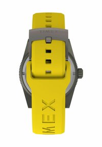 Reloj Timex con una caja de metal gris y una correa de silicona amarilla brillante con marca en relieve y múltiples agujeros de ajuste.
