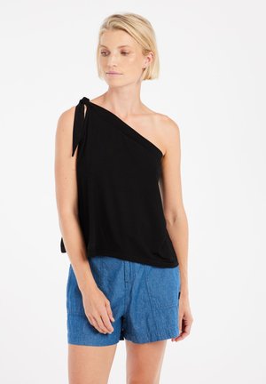 Zwarte top met één schouder en strikdetail, gemaakt van zachte stof. Gepaard met lichtblauwe shorts met een gestructureerde afwerking en zichtbare naden.