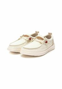 Zapatillas de lona tipo slip-on en color crema con una suela trenzada, detalles en rojo y una etiqueta de cuero beige. Cuentan con bandas elásticas para un fácil calzado.