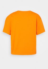 kortärmad t-shirt i klarröd bomull, avslappnad passform, rundad hals, slät textur, utan synliga mönster eller designer på baksidan.