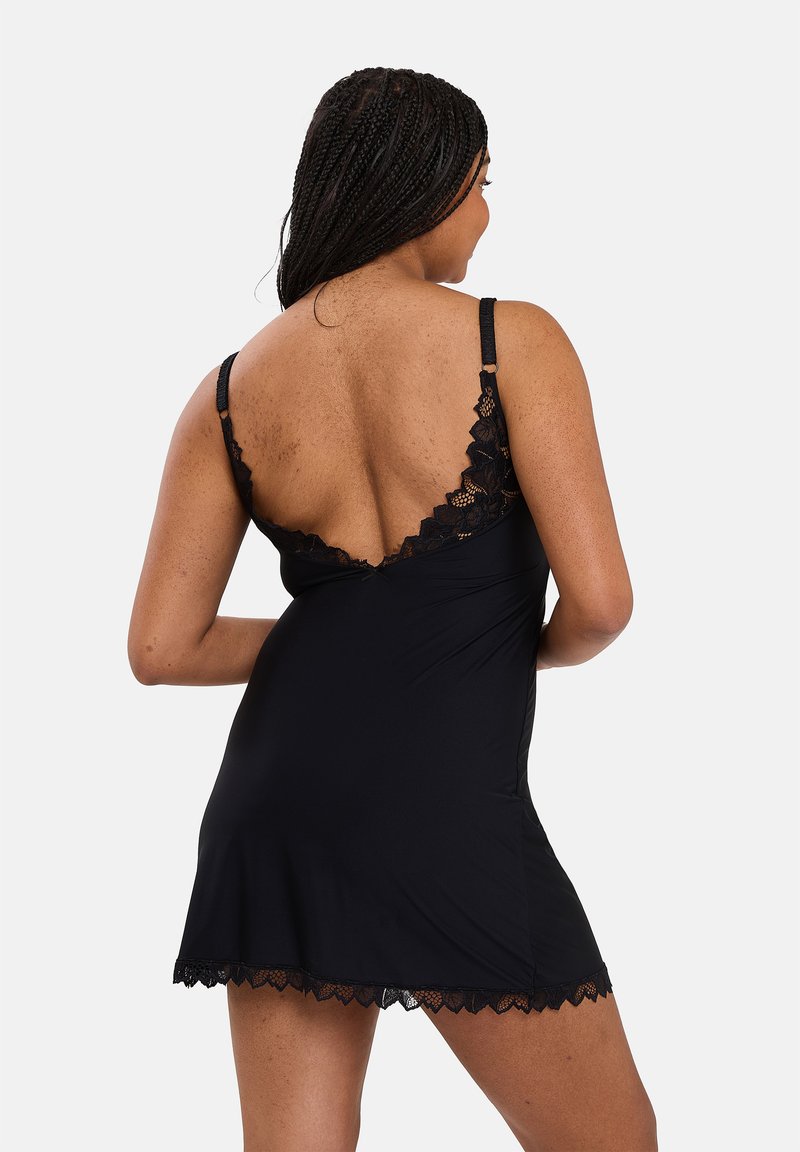 Black sleep dress with lace trim, featuring a V-back design and adjustable straps. Made from soft fabric; knee-length with scalloped edges.