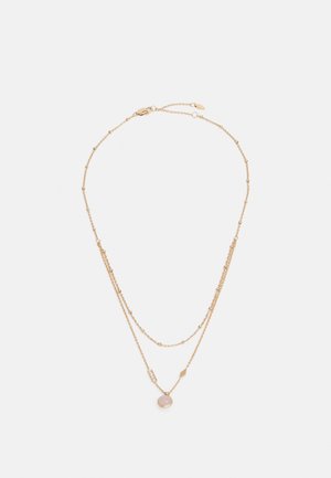 Delicate dubbele laag gouden ketting met kleine kraalaccenten, geometrische hangers en een ronde roze stenen hanger.