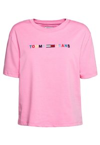 Rosa bomullströja med korta ärmar, med en broderad "TOMMY JEANS" logo i flerfärgade bokstäver och en rektangulär accent i röd, vit och blå.