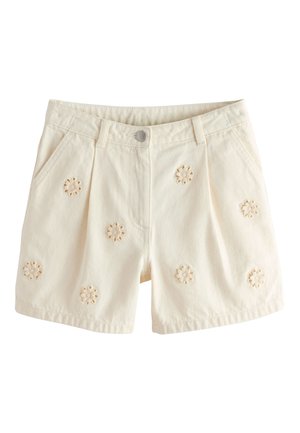Kremfarvede shorts med forlommer, knaplukning og broderede blomster mønstre spredt ud over stoffet.