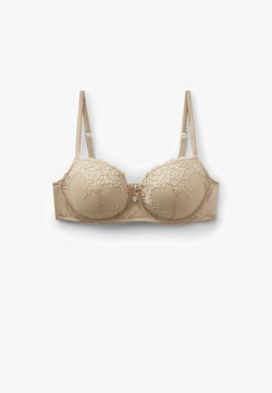 Beige kanten beha met gewatteerde cups, verstelbare bandjes en een klein hartvormig bedeltje in het midden.
