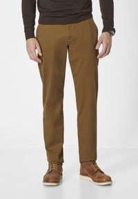 Braune Baumwollhosen mit geradem Schnitt, ausgestattet mit Seitentaschen und einer glatten Textur, kombiniert mit braunen Lederstiefeln und einem dunklen Pullover.