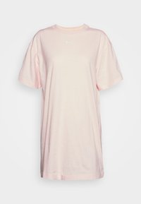 Světle růžové bavlněné tričko s krátkým rukávem, kulatým výstřihem a malým bílým logem Nike na hrudi. Jednoduchý, uvolněný střih.