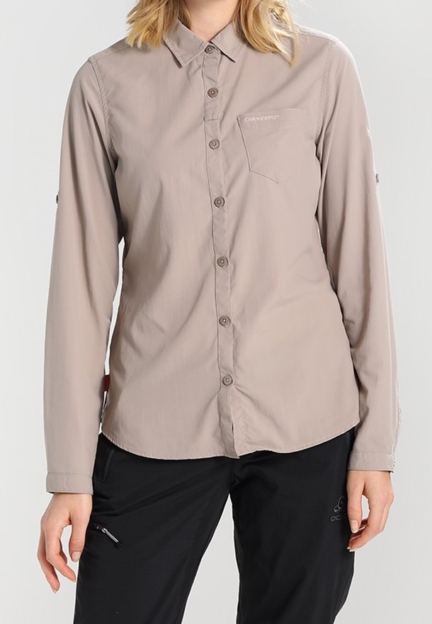 Camicia beige chiaro a maniche lunghe con collo, una tasca sul petto e maniche arrotolabili, realizzata in un tessuto leggero e liscio.