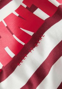 Rood-wit gestreepte stof met gedurfde tekst die duidelijk "Houd het echt" vermeldt, prominent weergegeven over het ontwerp.