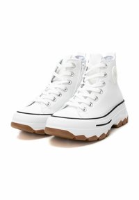 Sneaker alte bianche con tomaia in tela, suola in gomma, dettaglio a striscia nera e suola marrone texturizzata. Presentano chiusure con lacci e zip.