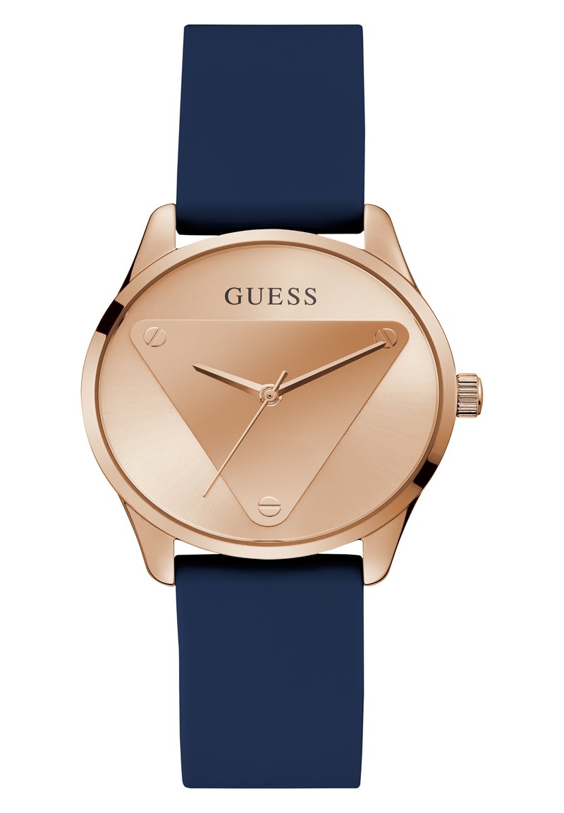 Orologio rose gold con quadrante triangolare, cinturino in silicone navy, design minimalista e movimento a tre lancette; presenta il logo 'GUESS' sul quadrante.