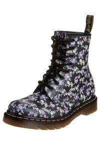 Svarta blommiga kängor med en glänsande finish, med snörning framtill, robust sula och gula sömmar runt kanten.