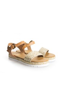 Ruske nahkasaapad koos kootud kuldsete rihmadega. Omab valget tekstureeritud tallat ja reguleeritavat pahkluu rihma, millel on pandla.