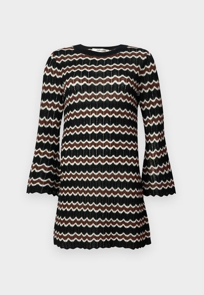 Robe tricotée à motif zigzag noir, blanc et marron avec des manches bell et un col rond, présentant un design en tissage ouvert texturé.
