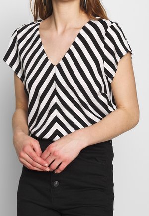 Zwart-witte gestreepte blouse met een v-hals, korte mouwen en een luchtig ontwerp. De strepen afwisselend in brede en smalle patronen.