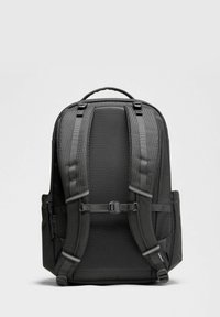 Sort rygsæk med tekstureret mesh-bagside og polstrede stropper. Har to sidelommer og et topgreb for nem bæring.