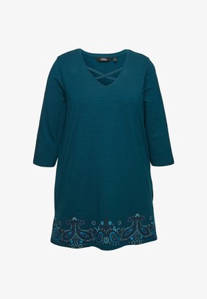 Türkisfarbige Tunika mit V-Ausschnitt und Kreuzdetail. Verfügt über 3/4-Ärmel und aufwendige florale Stickerei am Saum in verschiedenen Blautönen.