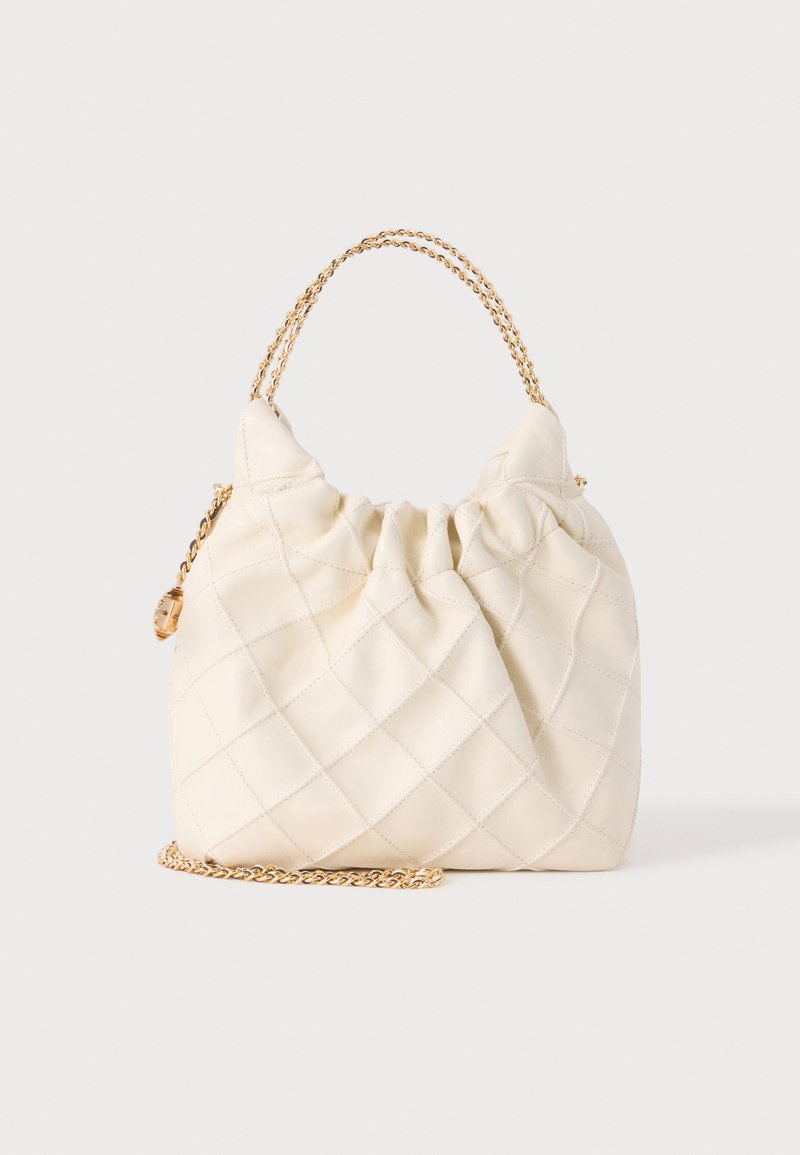Sac à main matelassé crème avec haut froncé et anses en chaîne dorée, debout sur une surface blanche unie.