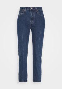 Dark blue denim jeans with a straight cut, featuring front pockets and a button closure. Subtle texture with visible stitching along seams.