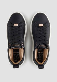 Sneaker nere con tomaia in pelle liscia, punta rotonda e suola in gomma bianca. Presentano lacci neri e dettagli in logo dorato sulla linguetta.