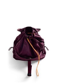 Borsa a coulisse di colore viola scuro con due cerniere laterali, cordino arancione, tessuto morbido e forma arrotondata. Dotata di una tracolla removibile.