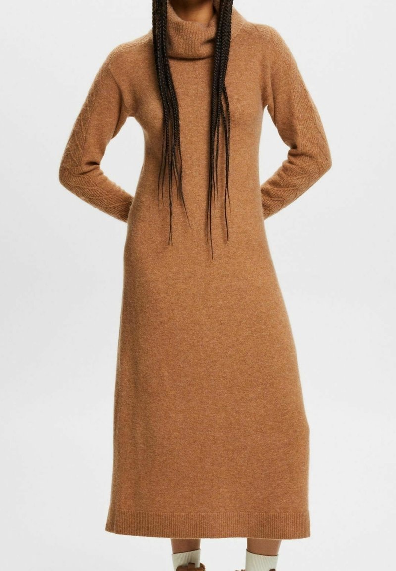 Robe en tricot marron avec un col drapé, des manches longues et des poignets côtelés, présentant une coupe décontractée et une longueur mi-mollet. Texture douce.