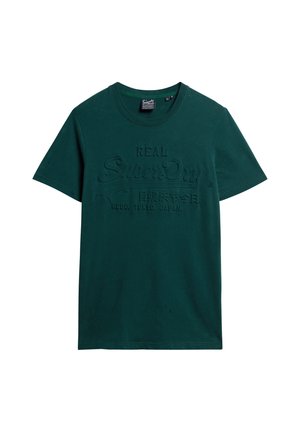 T-shirt en coton vert foncé avec des manches courtes et un col rond. L'avant présente un texte et des graphiques en relief de la même couleur.
