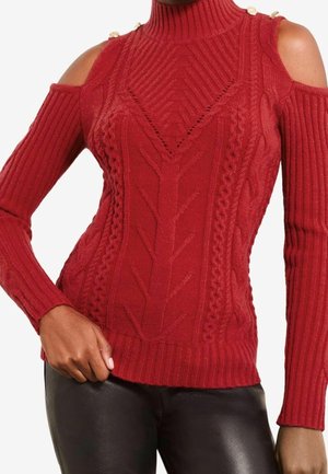 Pull en maille rouge avec découpes aux épaules, manches côtelées, motifs torsadés, col montant et détails de boutons dorés aux épaules.