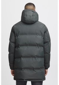 Mørkegrøn pufferjakke med hætte, med kviltede sektioner, en glat finish og et mellemlangt design. Slim-fit manchetter og kant.