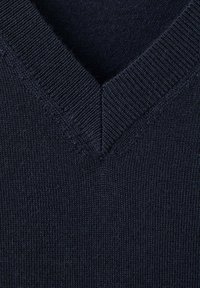 Gros plan sur un tissu tricoté bleu foncé avec un col en V présentant un bord côtelé.