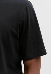 Czarny t-shirt z krótkimi rękawami, okrągłym dekoltem i gładką, miękką teksturą. Tylny widok ukazuje proste detale szwów.