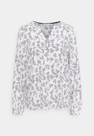 Weiße Bluse mit langen Ärmeln und V-Ausschnitt, mit schwarzem Blumenmuster, weicher Textur und knopfbaren Manschetten.