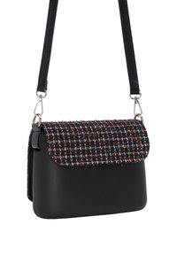 Svart läder crossbody-väska med en texturerad flerfärgad vävd klaff. Utrustad med silverfärgad hårdvara och justerbar rem. Kompakt rektangulär form.