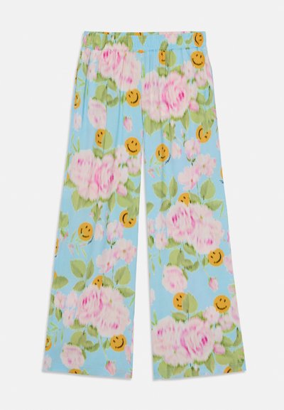 Calças com estampado floral em azul claro, apresentando rosas cor-de-rosa, folhas verdes e rostos sorridentes laranja. Corte descontraído com uma cintura elástica.
