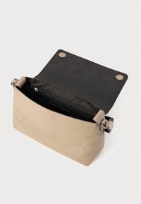 Beige læderhåndtaske med struktureret overflade, åben flap, sort indvendig foring, lynlåslomme og trykknaplukning. Har justerbar skulderrem.